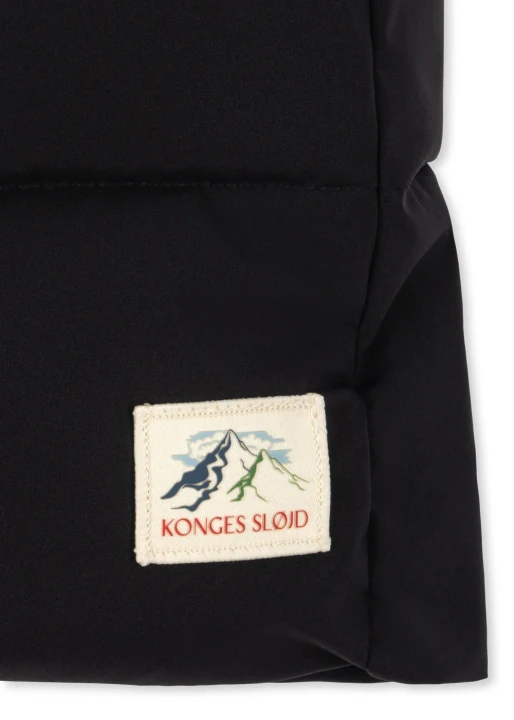 Konges Sløjd Alpi Long Black – detal naszywki marki na dole kurtki