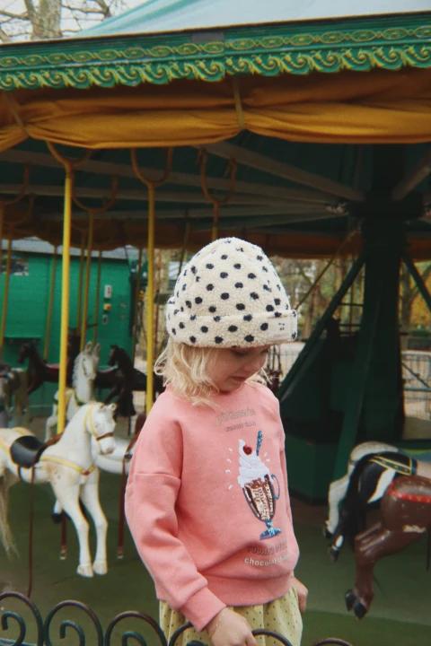 Różowa bluza Konges Sløjd Lou Peach Blossom w dziecięcej stylizacji z czapką