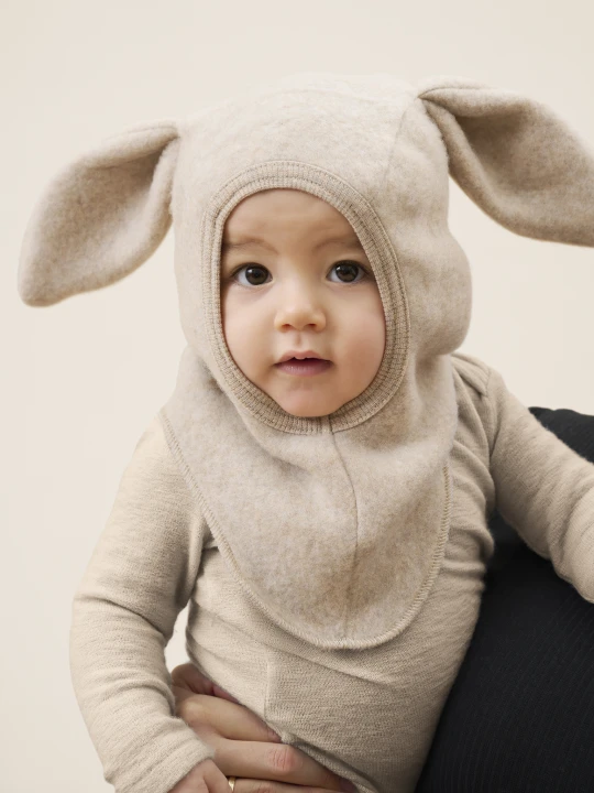 HUTTEliHUT Balaclava Ears Camel Melange – kominiarka merino prezentowana na dziecku