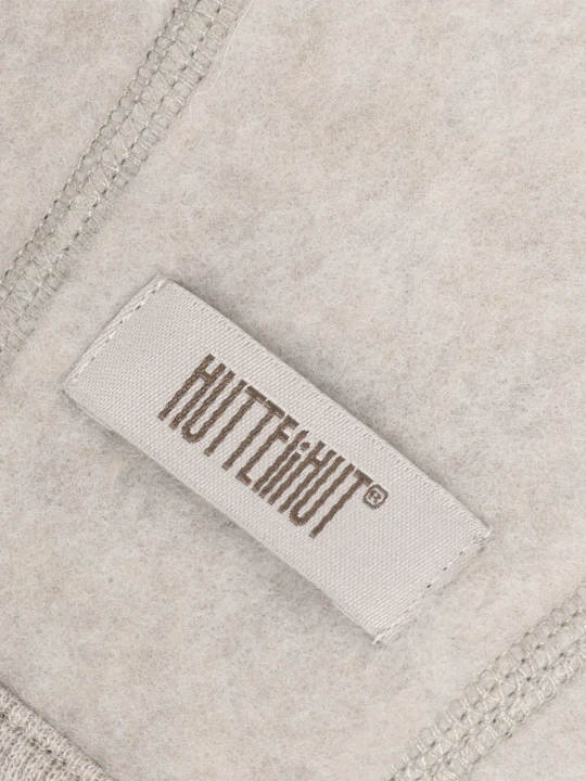 Detal czapki HUTTEliHUT Bonnet Wool Fleece Camel Melange – wełniany materiał i metka producenta