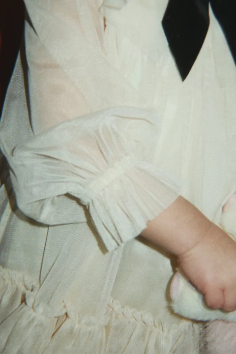 Sukienka tiulowa Bow Dress Parchment – detal rękawa i warstw tkaniny podczas noszenia.