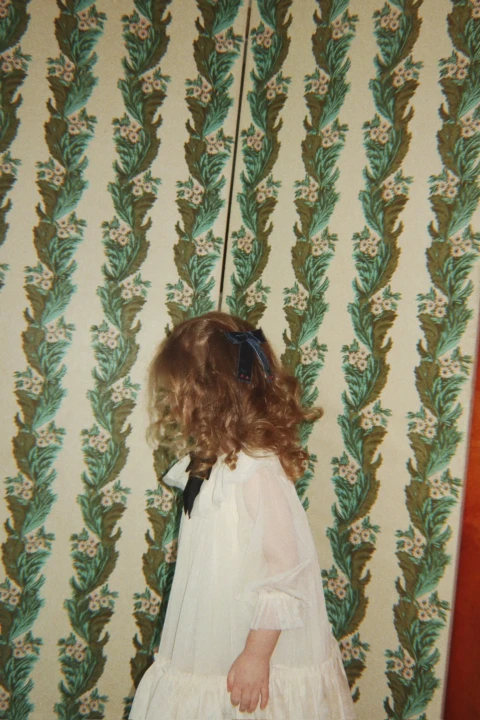 Konges Sløjd Bow Dress Parchment – sukienka pokazana z boku na dziecku.