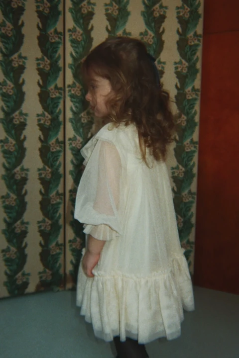 Bow Dress Parchment – warstwowy fason sukienki widoczny podczas noszenia.