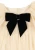 Konges Sløjd Bow Dress Parchment – detal czarnej welurowej kokardy przy dekolcie.