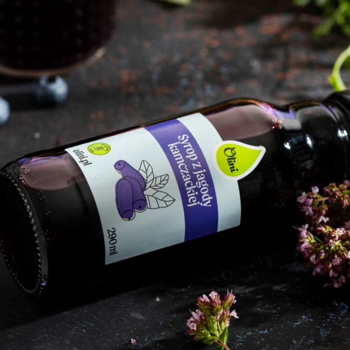 Syrop z jagody kamczackiej Olini 290 ml – butelka w aranżacji z kwiatami