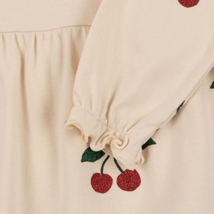 Rozkloszowany dół sukienki dziecięcej Konges Sløjd z printem wiśni.