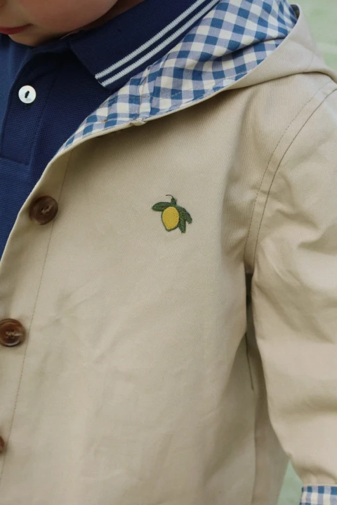 Detal stylizacji z granatową koszulką polo dziecięcą.
