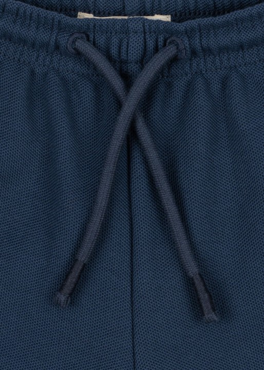 Detal pasa i sznurka granatowych spodenek dziecięcych.