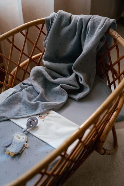 Otulacz muślinowy niebieski w delikatne listki w koszu