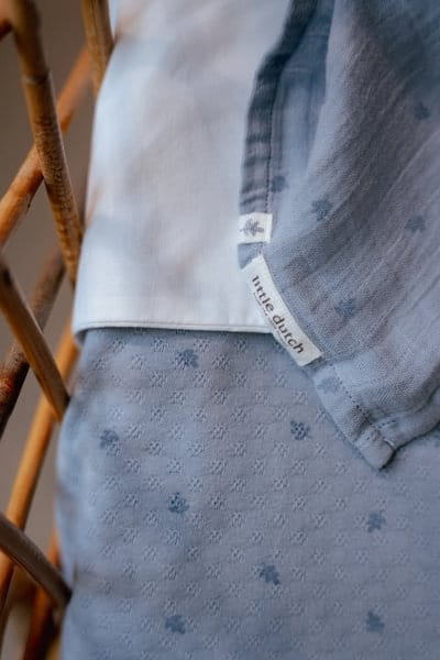 Otulacz muślinowy niebieski w delikatne listki na zbliżeniu