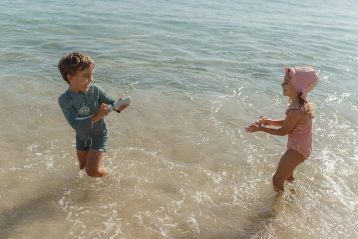 Dziecko biegnie z piankowym pistoletem na wodę Dreamy Mermaid przy brzegu