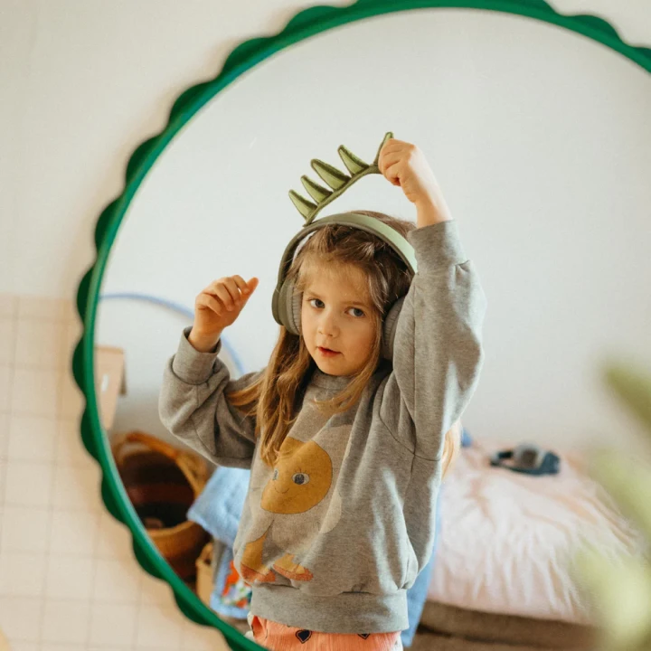 KIDYWOLF KIDYEARS Dino, dziecko w słuchawkach przed lustrem