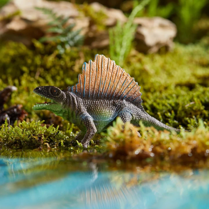 Figurki dinozaurów w zielonej prehistorycznej scenerii nad wodą