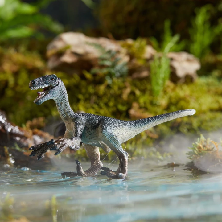Figurka drapieżnego dinozaura w realistycznej scenerii jurajskiej