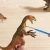 Dziecko bawiące się figurką drapieżnego dinozaura Mideer