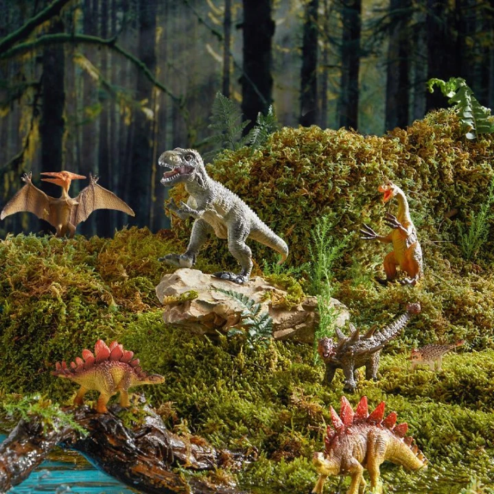 Różne figurki dinozaurów Mideer wśród skał, roślin i wody