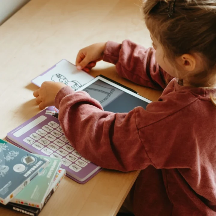 Dziecko korzysta z tabletu KIDYDRAW MINI Princess i tematycznych kart do odrysowywania