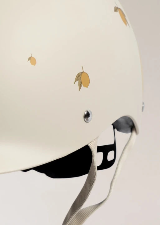 Konges Sløjd Bicycle Helmet Lemon kask rowerowy dziecięcy – zbliżenie skorupy i mocowania paska