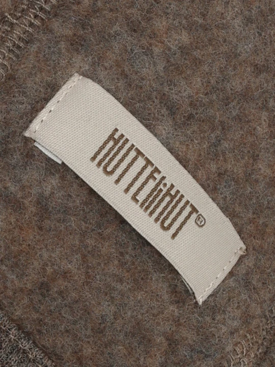 Detal czapki HUTTEliHUT Bonnet Wool Fleece – wełniany materiał i metka producenta