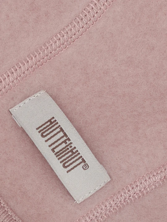 Detal czapki HUTTEliHUT Bonnet Wool Fleece – wełniany materiał Mahogany Rose i metka marki