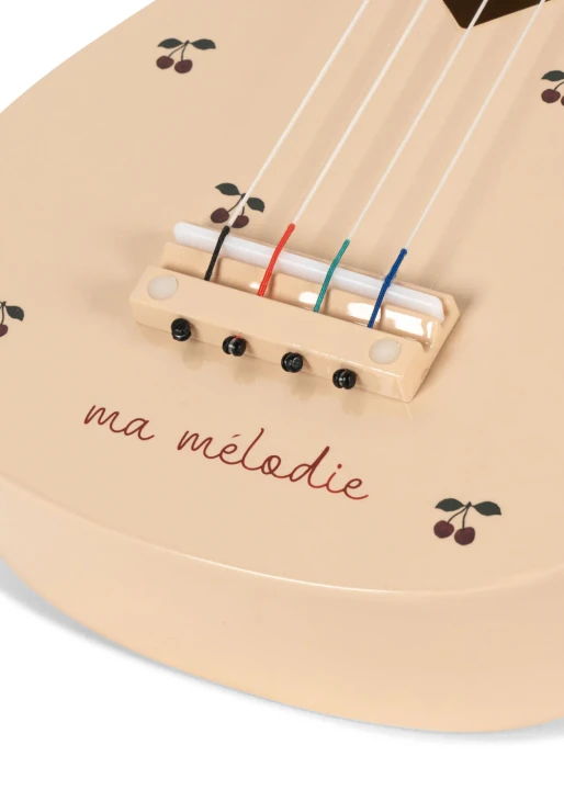 Konges Sløjd ukulele Glossy Cherry – zbliżenie na struny, mostek i wzór wiśni