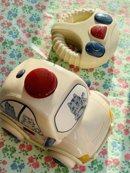 Konges Sløjd Remote Control Police Car Beige samochód i pilot na kwiecistym tle