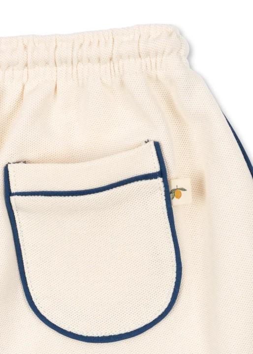 Florian Shorts Antique White, detal tylnej kieszeni z granatowym obszyciem