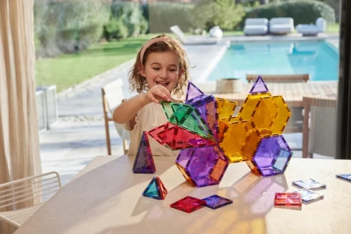 Cleverclixx Geo Pack Pastel 45 elementów – dziewczynka budująca geometryczną konstrukcję