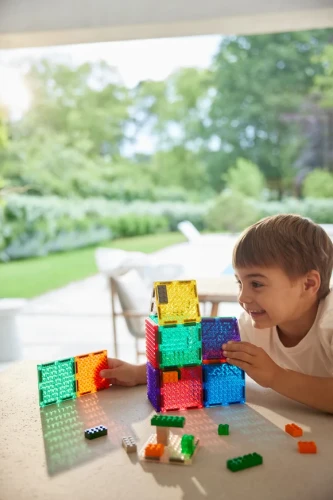 Cleverclixx Brick Tiles Pack Intense 16 elementów, chłopiec budujący przy stole