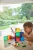 Cleverclixx Brick Tiles Pack Intense 16 elementów, chłopiec budujący przy stole